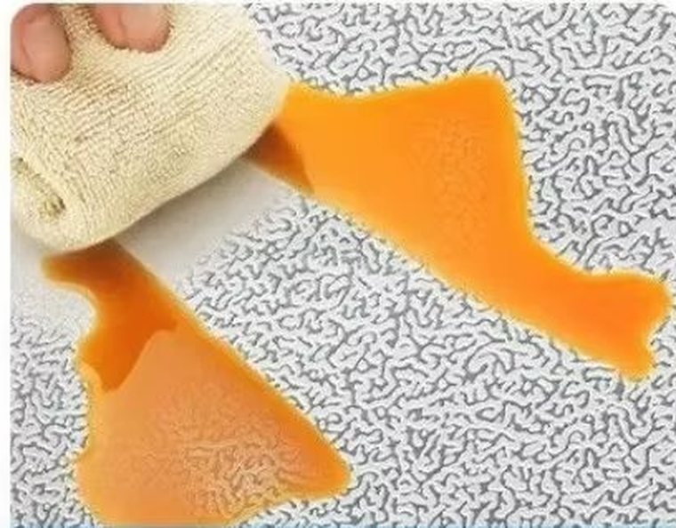 A spill of oil being wiped off the foil with a cloth